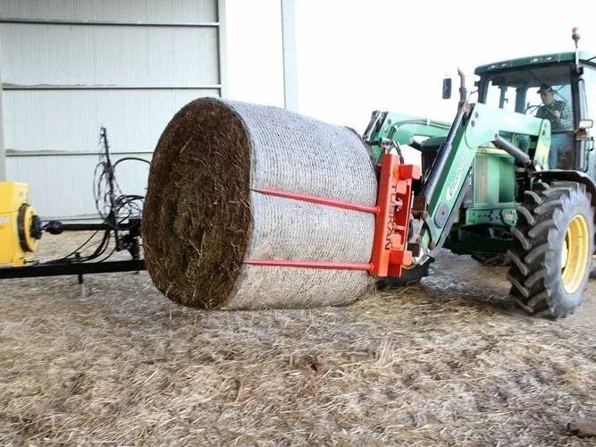 Tuskan carrying a round bale with a tractor
